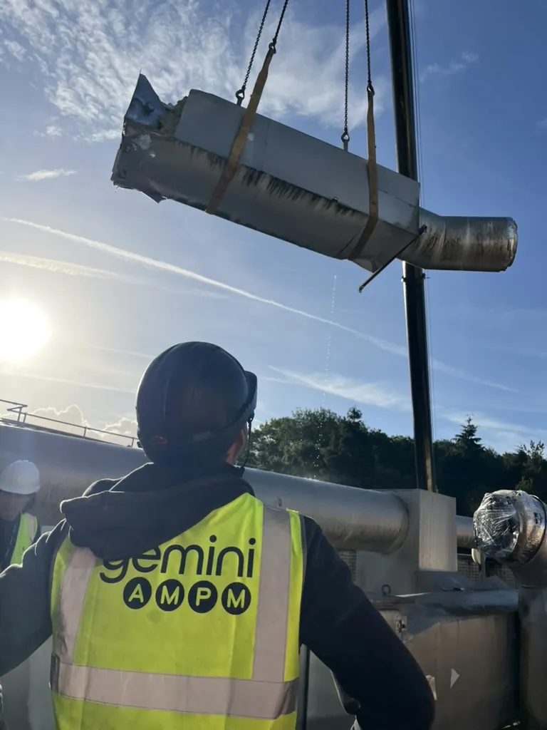 A Gemini AMPM engineer on the roof at Hutwood Court as a section of old lagged ductwork is lifted clear by crane