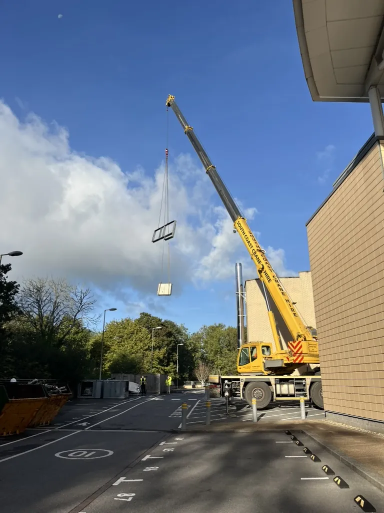 Mobile crane set up in the car park beside Hutwood Court with a section of plant in the air