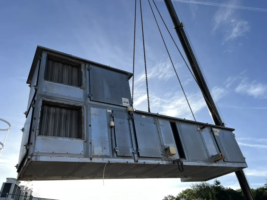 An L-shaped section of redundant air handling unit in the air on chains