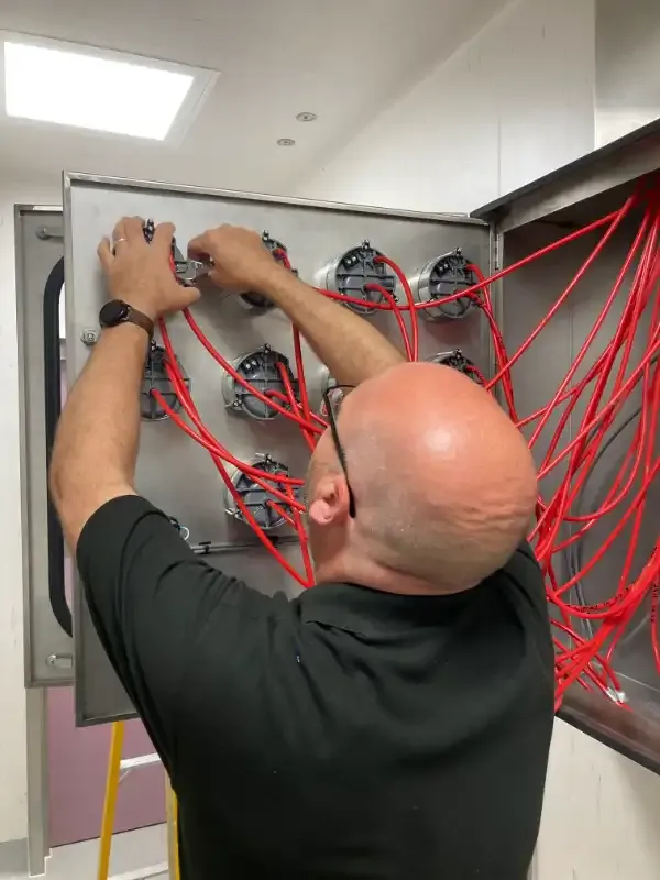 Engineer connecting test lines during cleanroom commissioning