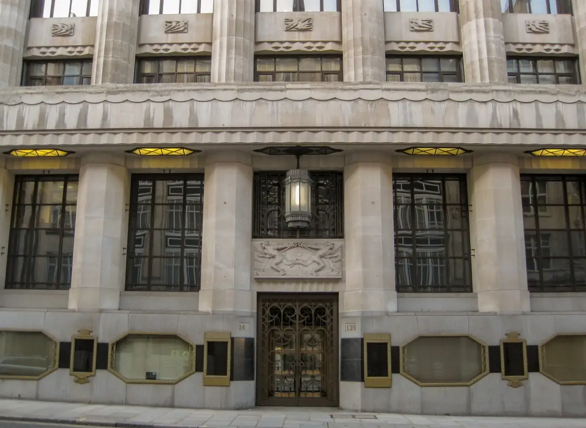 The bronze-gated entrance to 135 Fleet Street with its stone relief and lantern