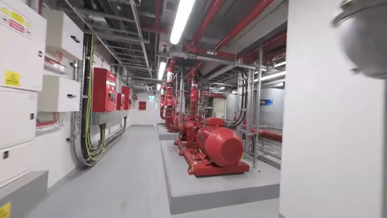 Fire pump sets and red pipework in a basement plant room at Peterborough Court